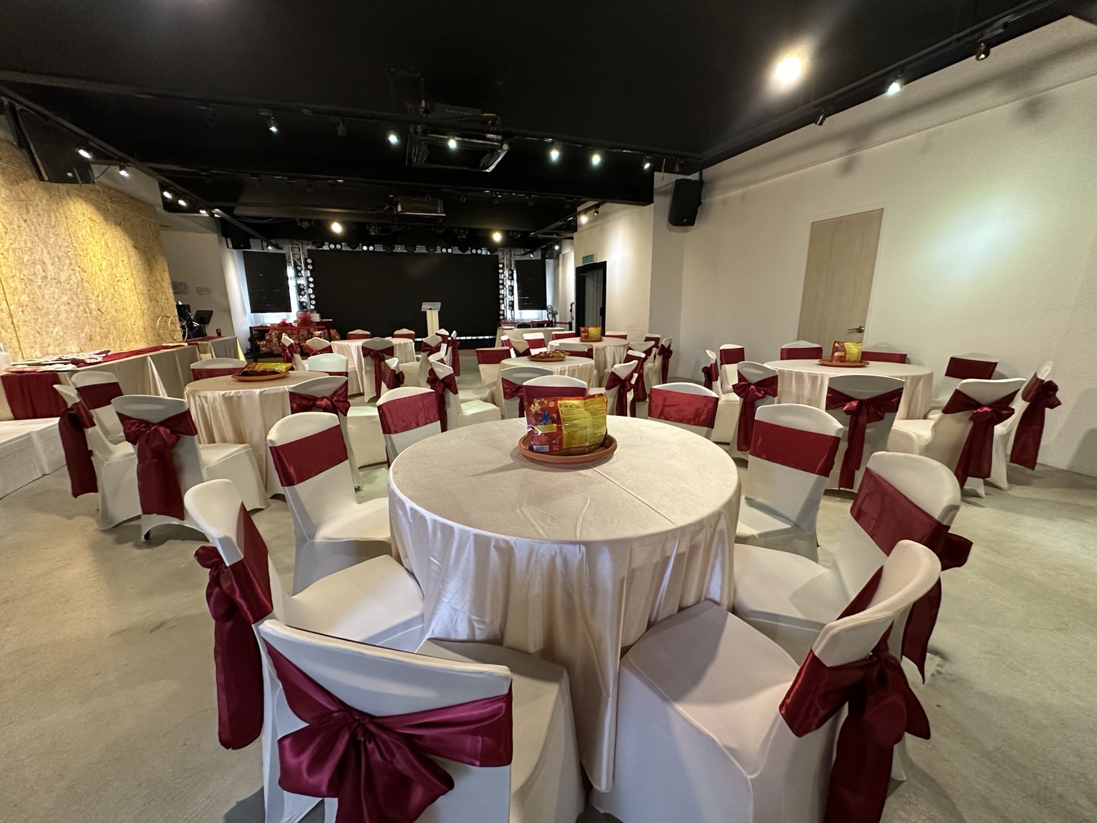 Banquet setup with round tables and ribbon-tied chairs at Dreamlive Event Space