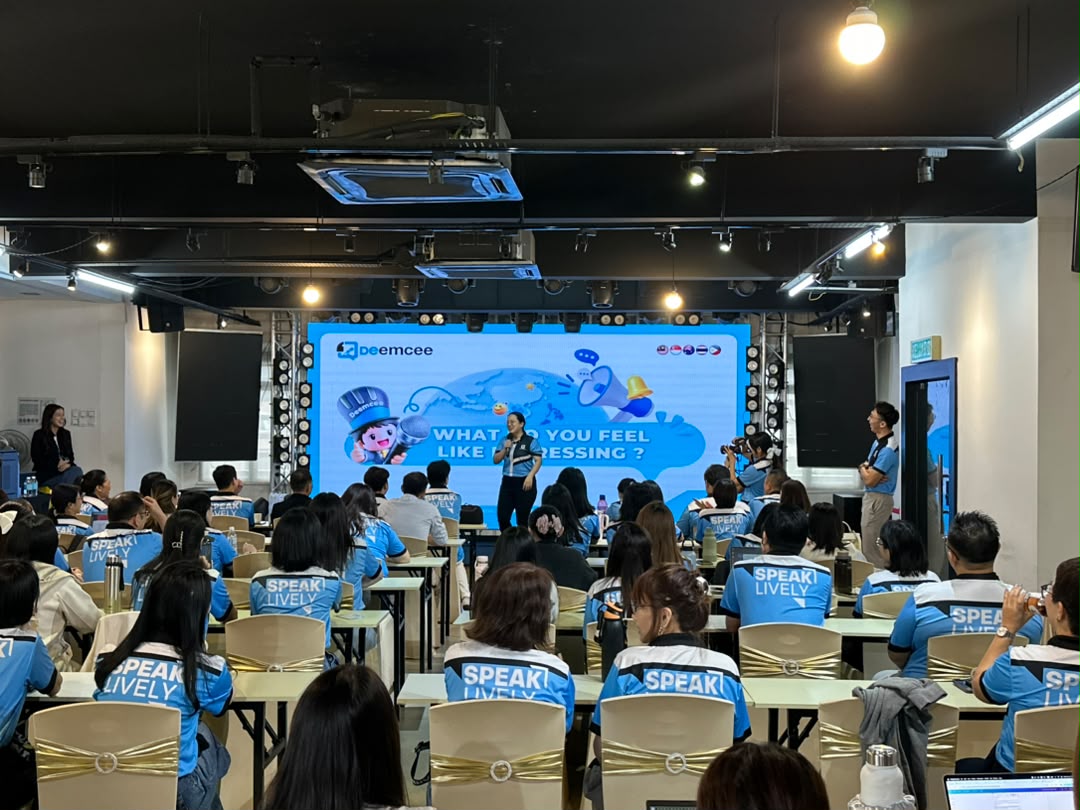 Full-house corporate training with participants in uniform at classroom tables facing the LED screen at Dreamlive Event Space Puchong