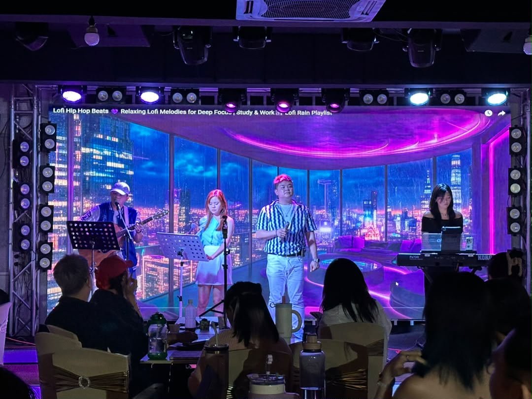 Live band performing on stage with city backdrop on the LED screen at Dreamlive Event Space Puchong