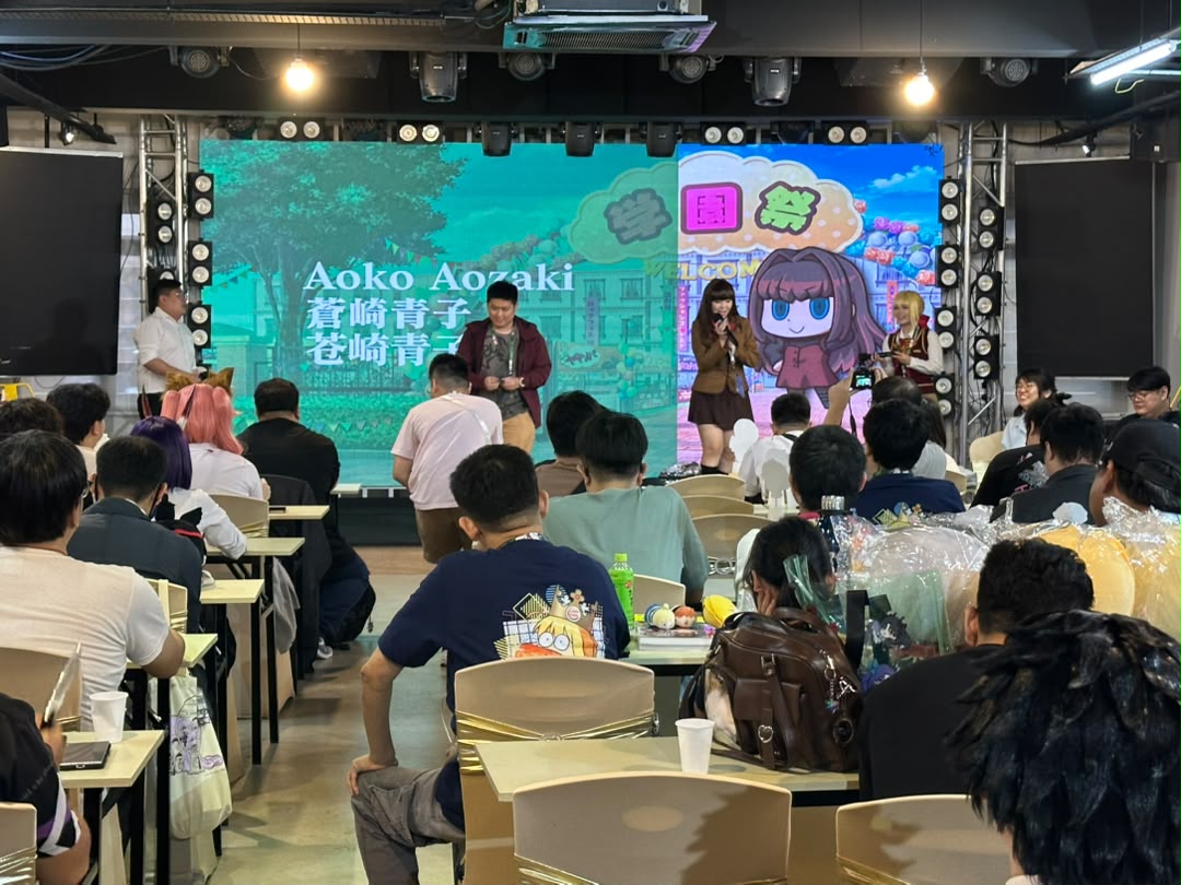 Anime and cosplay community event with guests at tables facing the stage at Dreamlive Event Space Puchong