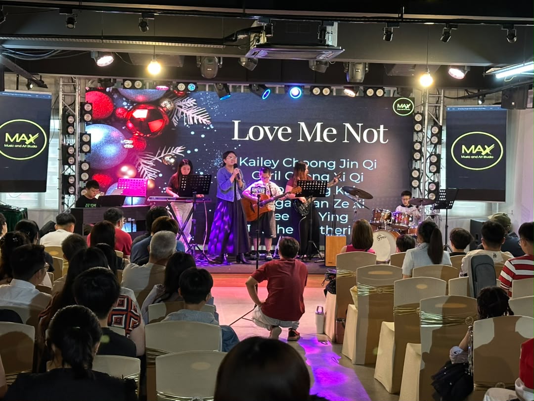 Student music showcase with live band on stage and a full audience at Dreamlive Event Space Puchong