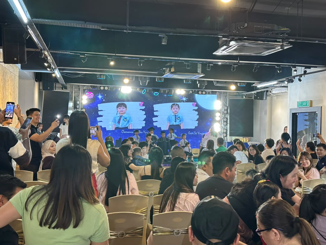 Larger showcase with a full audience of guests facing the stage at Dreamlive Event Space Puchong